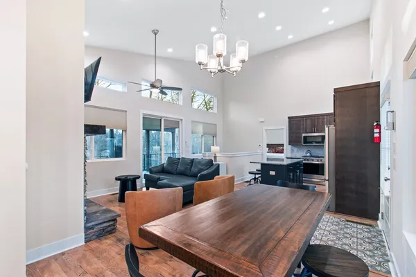 a view of a dining room with furniture a chandelier and wooden floor