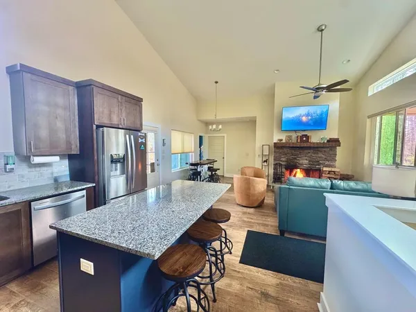 a kitchen with stainless steel appliances granite countertop a stove refrigerator and a sink
