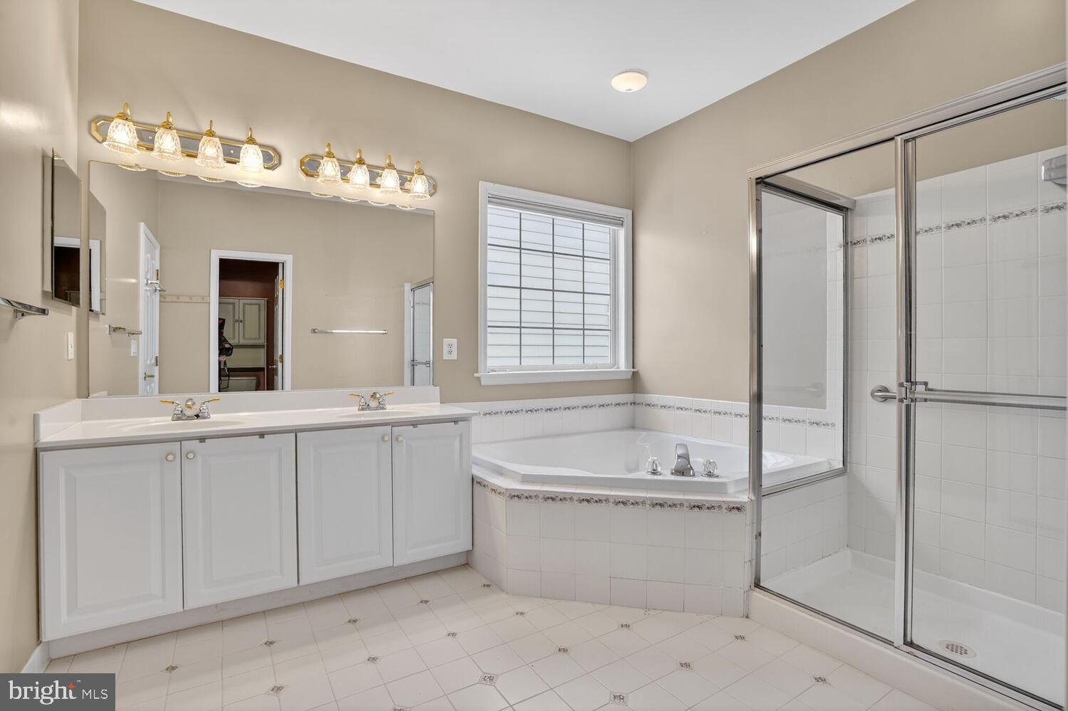6767 Derby Run Way Gainesville, VA 20155 - Photo 12 of 37 a bathroom with a tub a sink and mirror