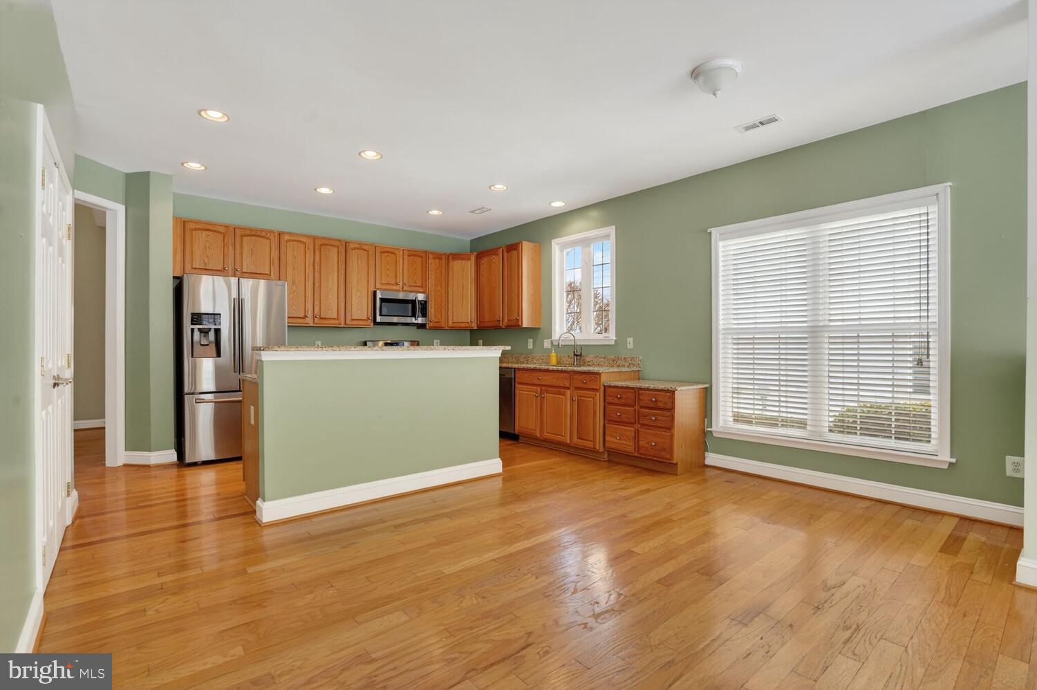 6767 Derby Run Way Gainesville, VA 20155 - Photo 20 of 37 a kitchen with stainless steel appliances kitchen island wooden cabinets and a refrigerator