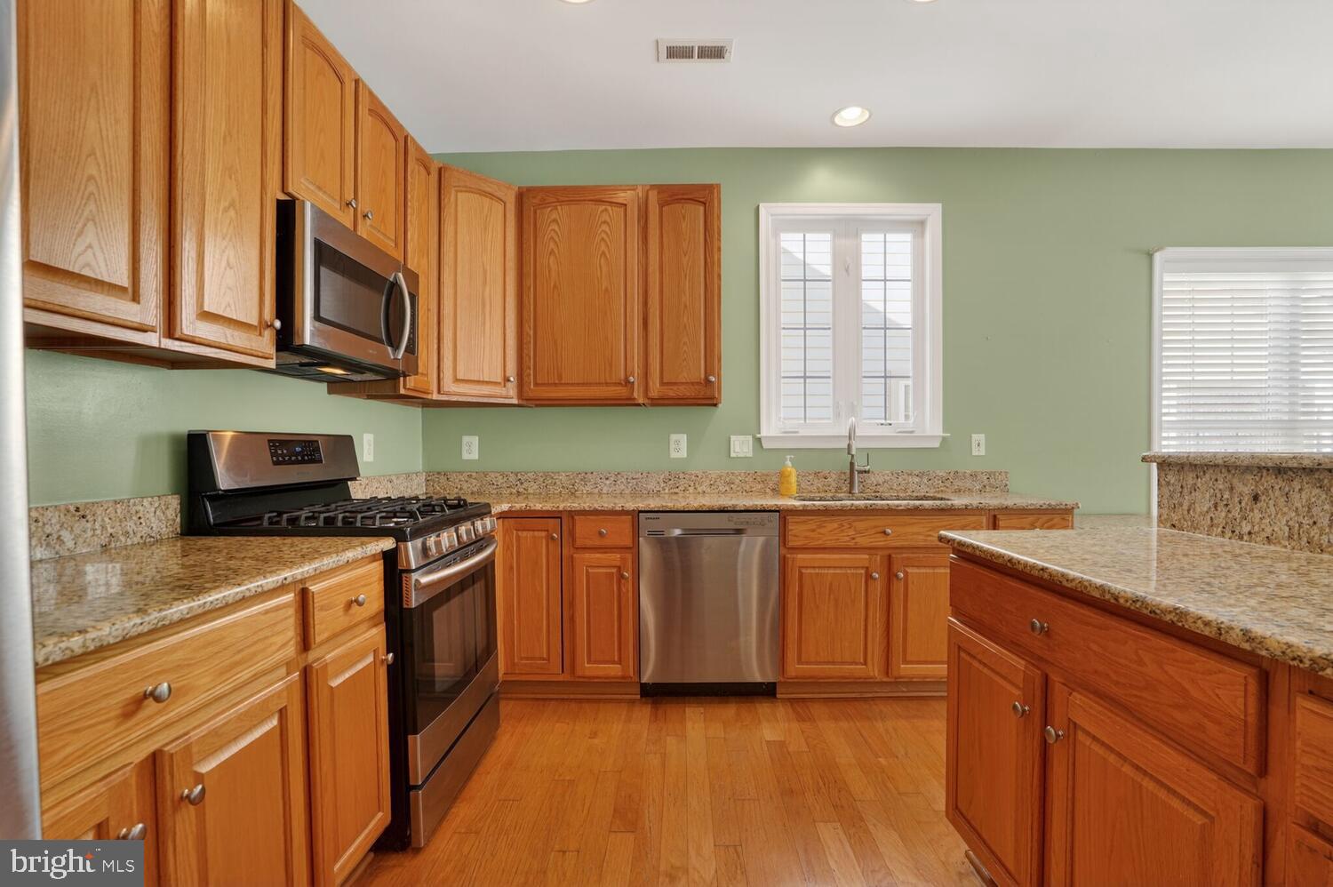 6767 Derby Run Way Gainesville, VA 20155 - Photo 5 of 37 a kitchen with stainless steel appliances granite countertop wooden cabinets a sink and a stove