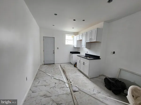 a kitchen with granite countertop white cabinets and appliances
