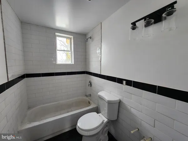a white toilet sitting next to a bath tub