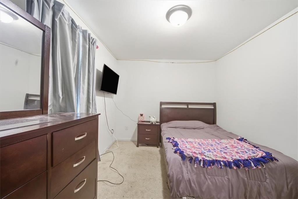 6283 Susan Lane Doraville, GA 30340 - Photo 16 of 34 a bedroom with a bed and a flat tv screen on dresser