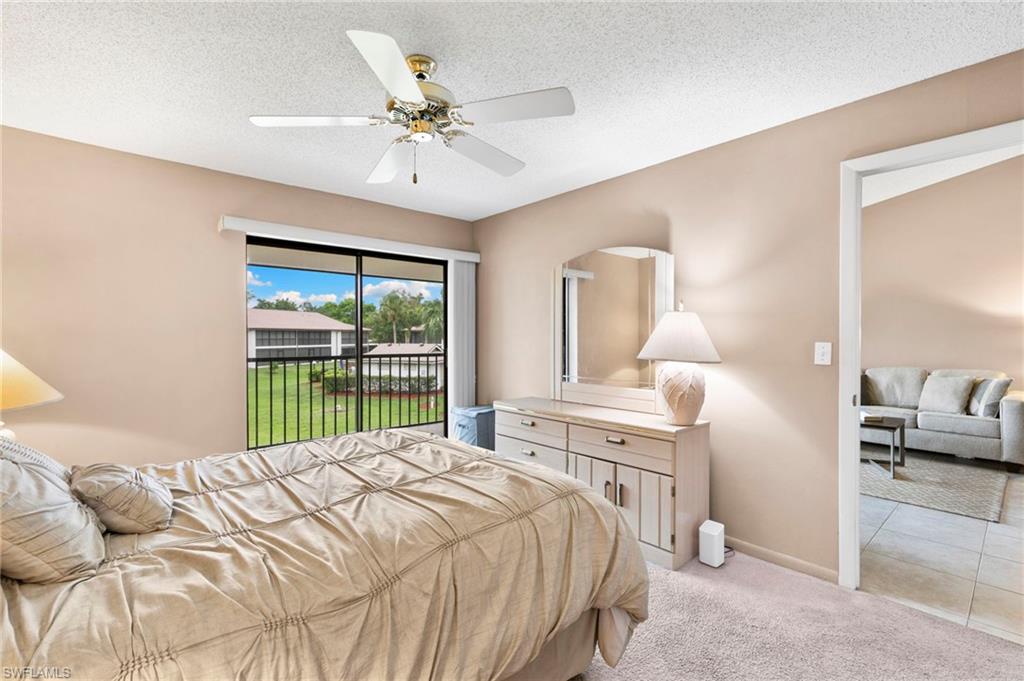 236 Pebble Beach Circle, Unit A202 Naples, FL 34113 - Photo 13 of 25 a bedroom with a large bed and a chandelier