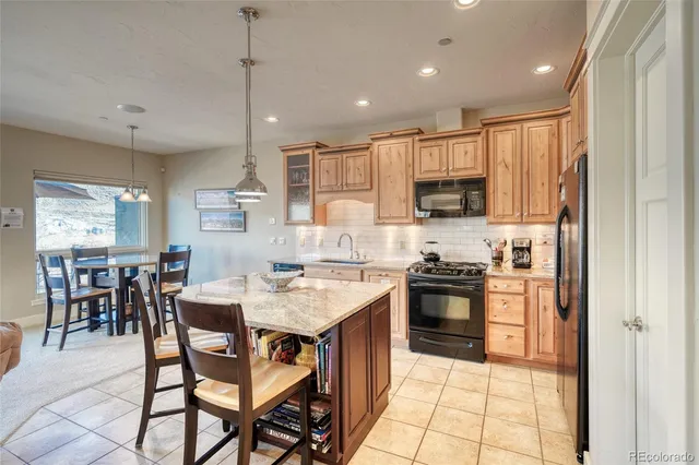 a kitchen with stainless steel appliances granite countertop a stove top oven a sink refrigerator and cabinets