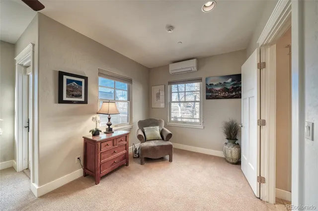 a spacious bedroom with a bed a table and large windows