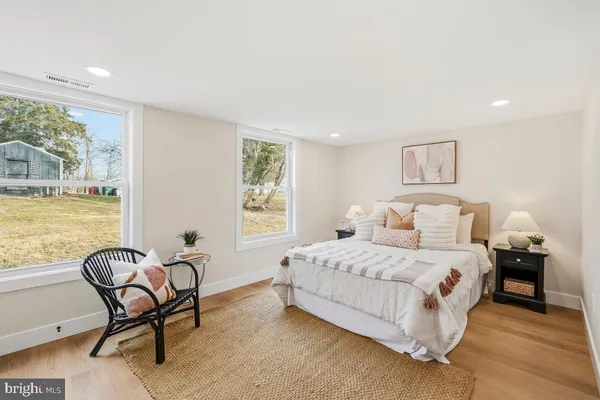 a bedroom with a bed chair and window