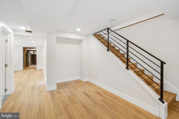 a view of a hallway with wooden floor and staircase