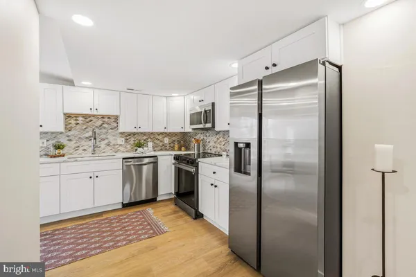 a kitchen with a refrigerator sink and cabinets