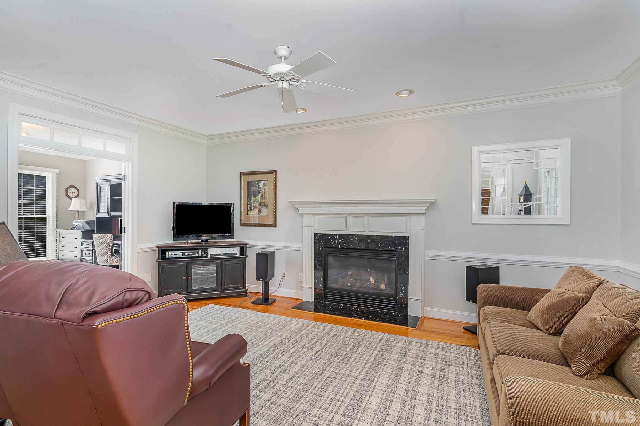 9409 Stone Mountain Road Raleigh, NC 27613 - Photo 12 of 53 a living room with furniture a flat screen tv and a fireplace