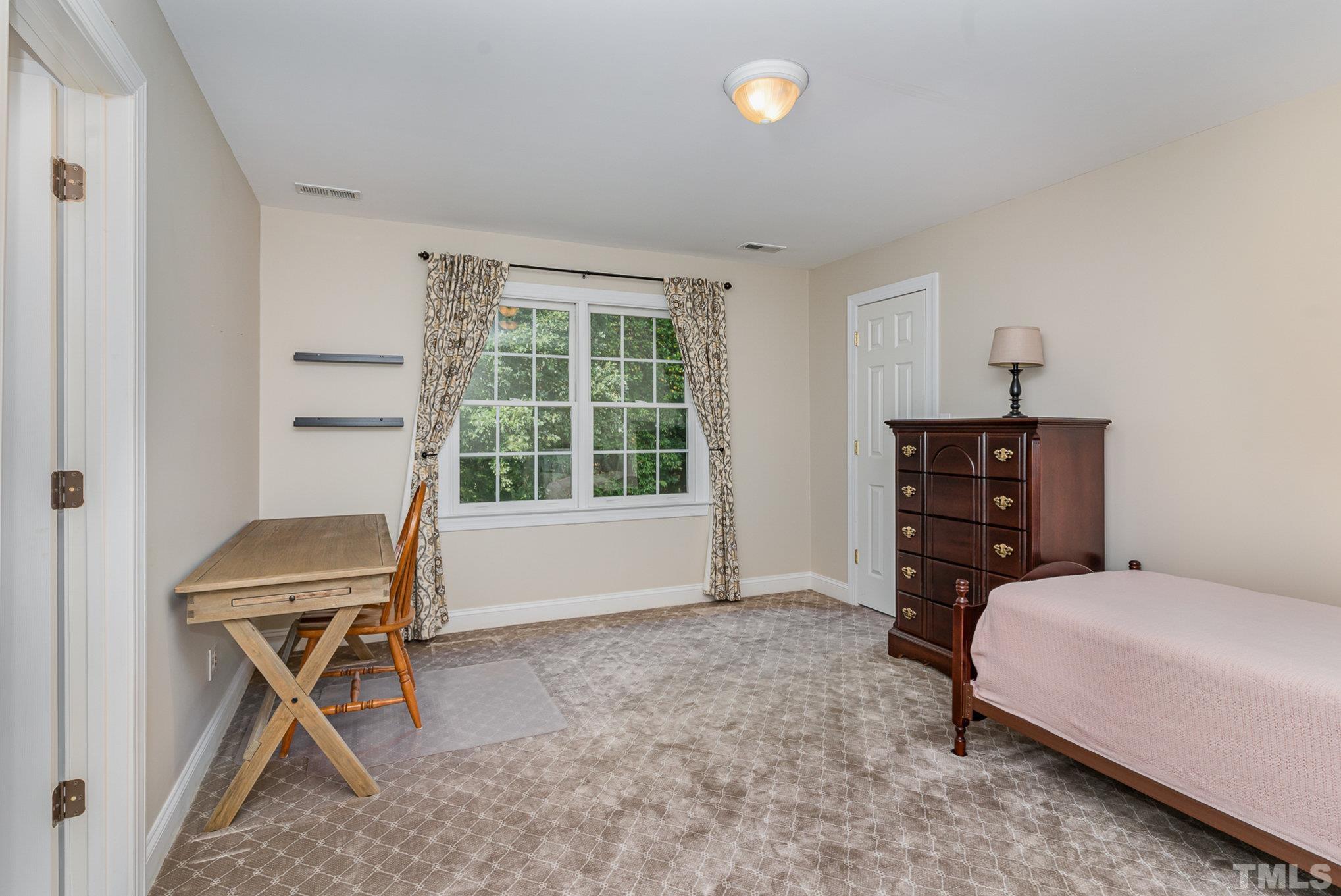 9409 Stone Mountain Road Raleigh, NC 27613 - Photo 30 of 53 a bedroom with a bed and a window