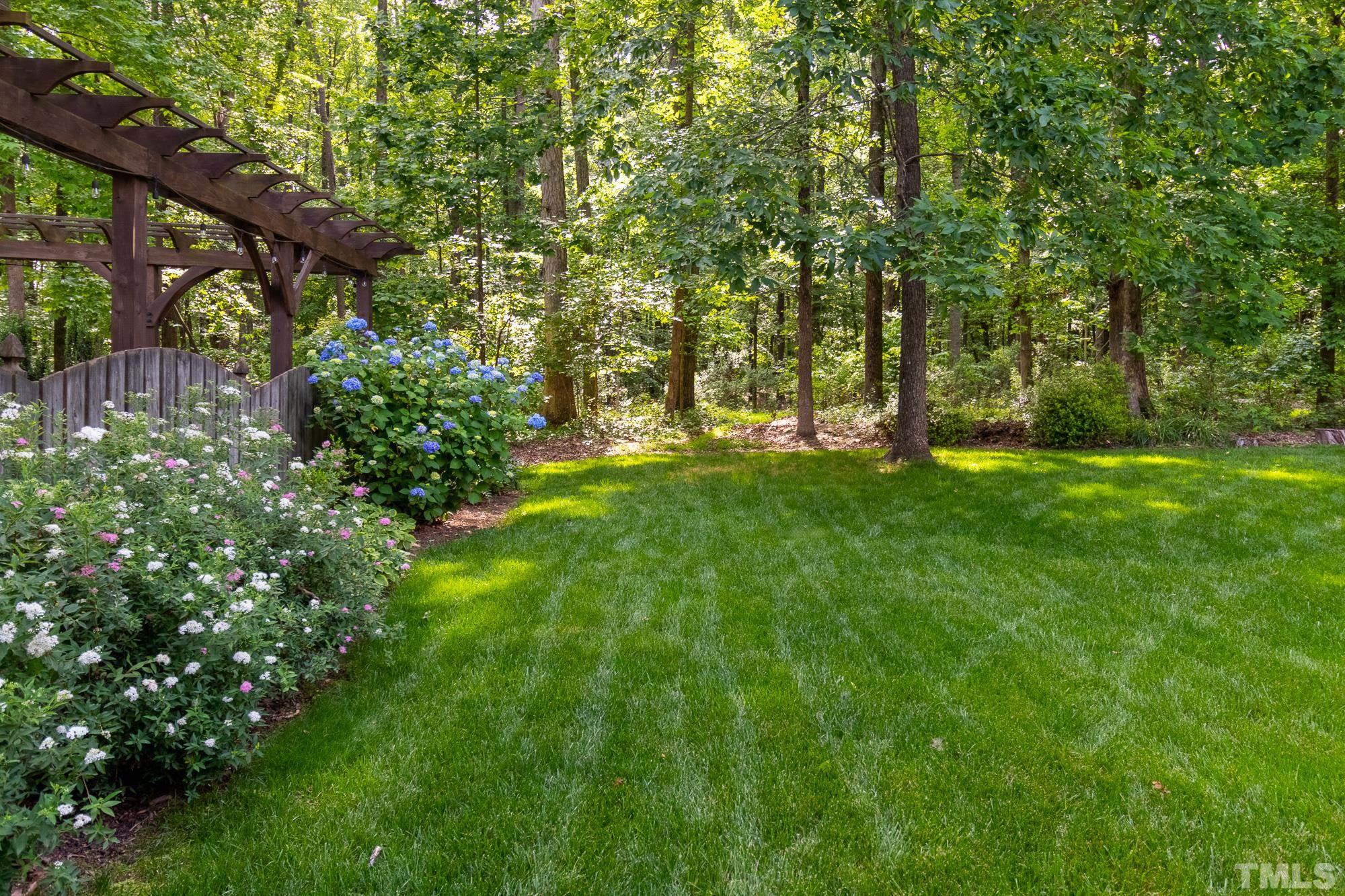 9409 Stone Mountain Road Raleigh, NC 27613 - Photo 40 of 53 a backyard of a house with lots of green space and fountain