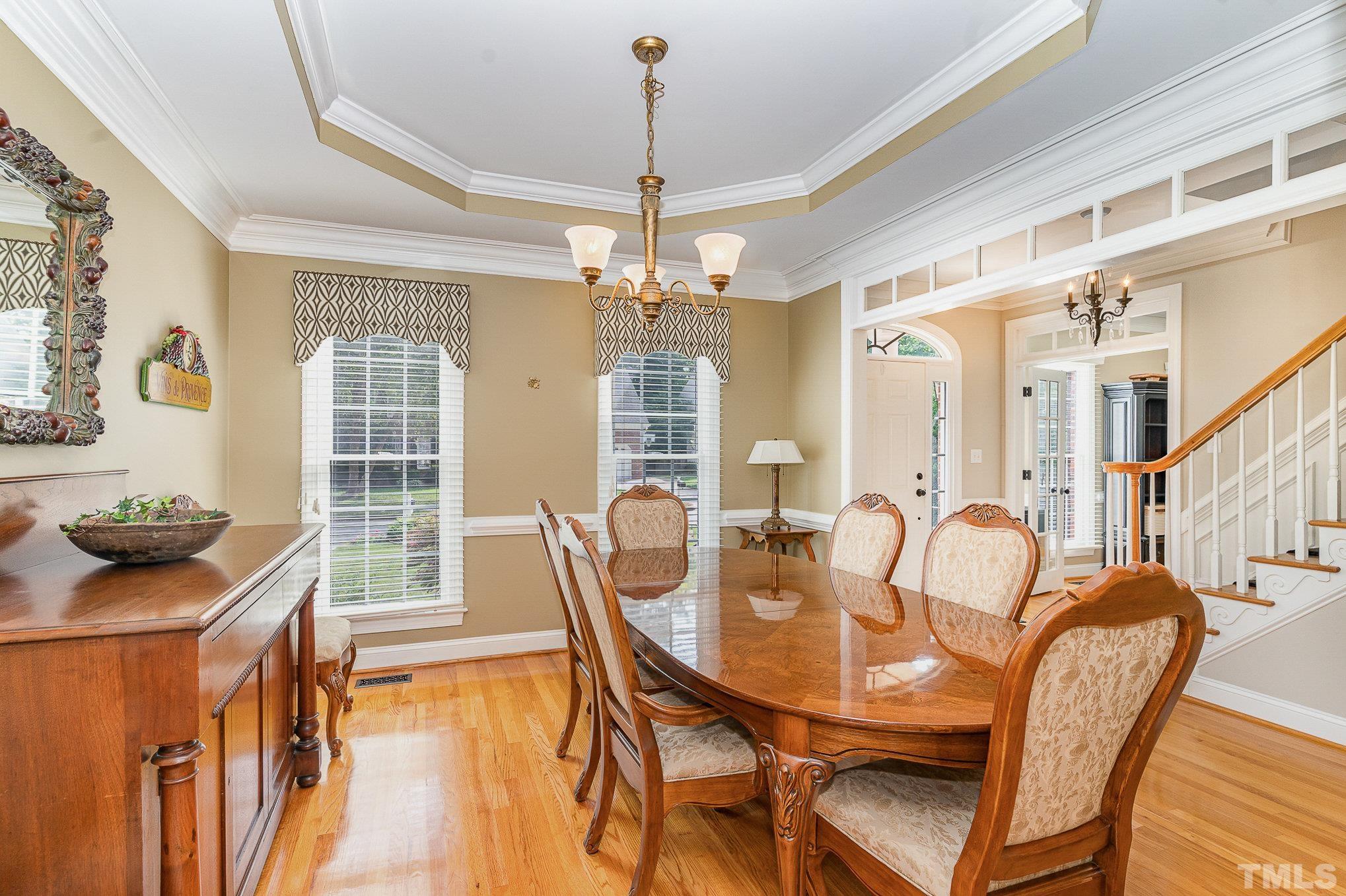 9409 Stone Mountain Road Raleigh, NC 27613 - Photo 8 of 53 a dining room with furniture a chandelier and wooden floor