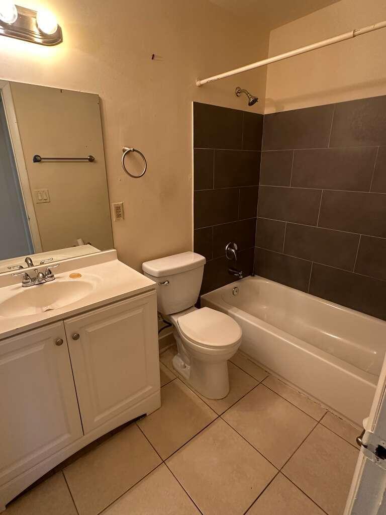 1239 Southwest 46th Avenue, Unit 906 Pompano Beach, FL 33069 - Photo 12 of 21 a bathroom with a toilet a sink and shower