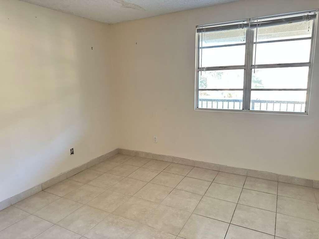 1239 Southwest 46th Avenue, Unit 906 Pompano Beach, FL 33069 - Photo 4 of 21 an empty room with a window