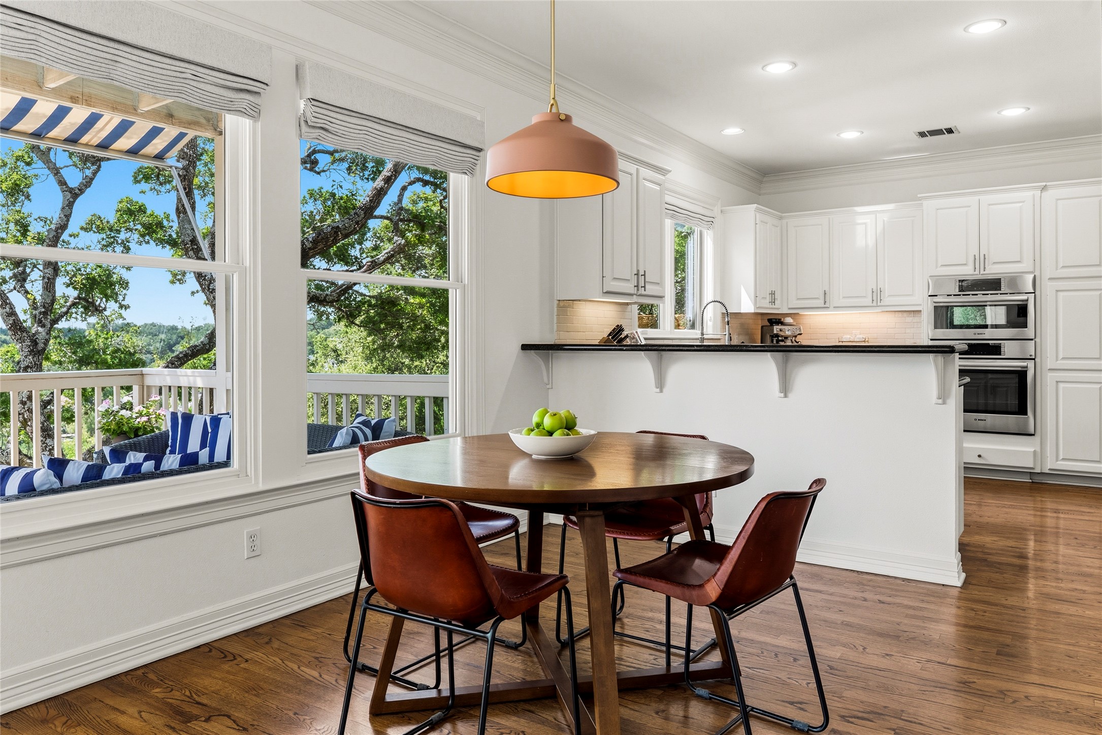 3107 Lookout Lane Austin, TX 78746 - Photo 14 of 39 Hardwood floors and generous windows frame the bright kitchen, offering picturesque outdoor views.