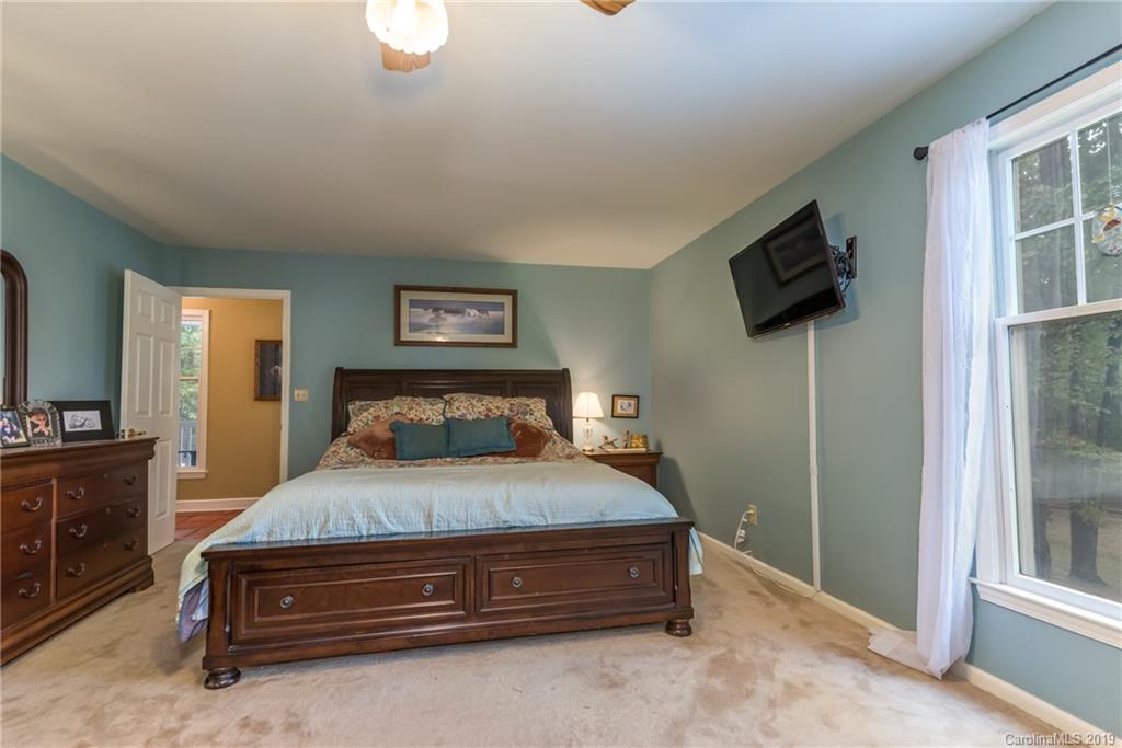 295 Mockingbird Hill Road Landrum, SC 29356 - Photo 22 of 38 a bedroom with a bed a flat screen tv and window