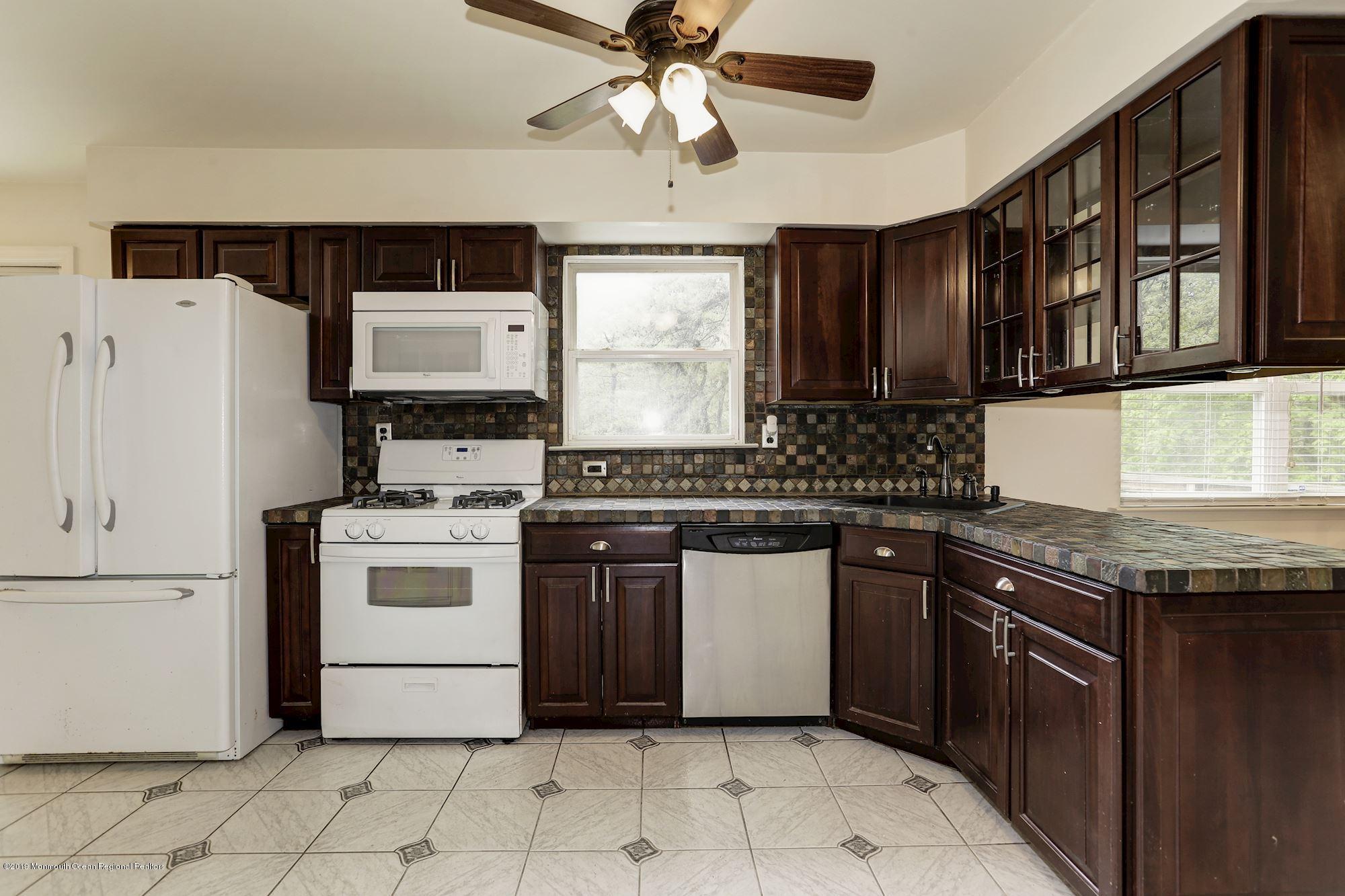 460 Cedar Swamp Road Jackson, NJ 08527 - Photo 12 of 38 a kitchen with a stove sink and cabinets