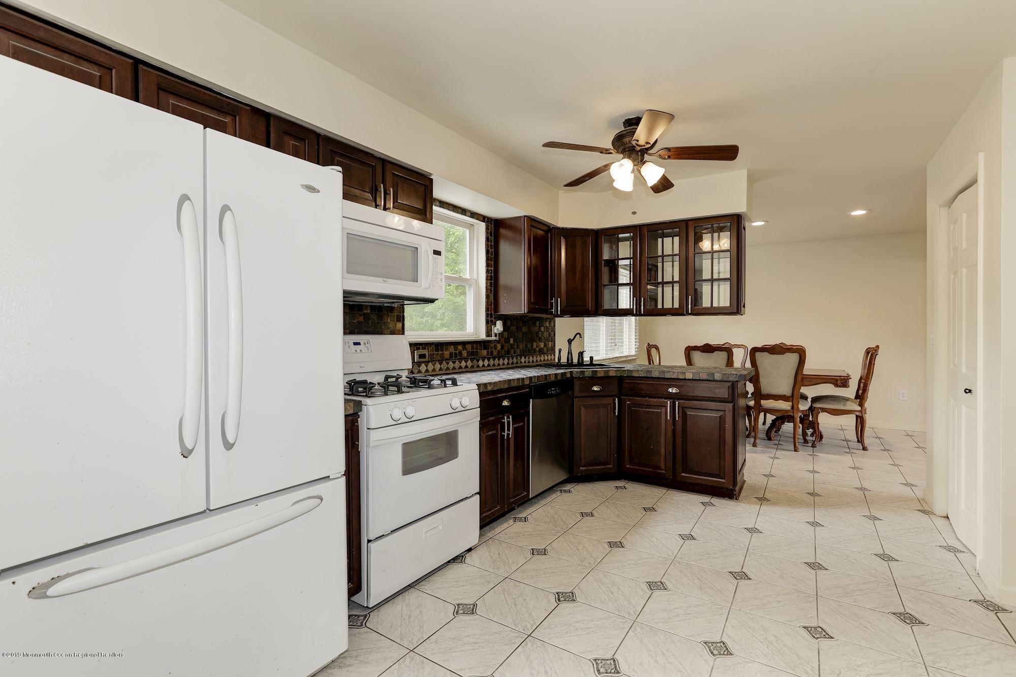 460 Cedar Swamp Road Jackson, NJ 08527 - Photo 13 of 38 a kitchen with stainless steel appliances granite countertop a stove a sink dishwasher a refrigerator and a microwave oven with white cabinets