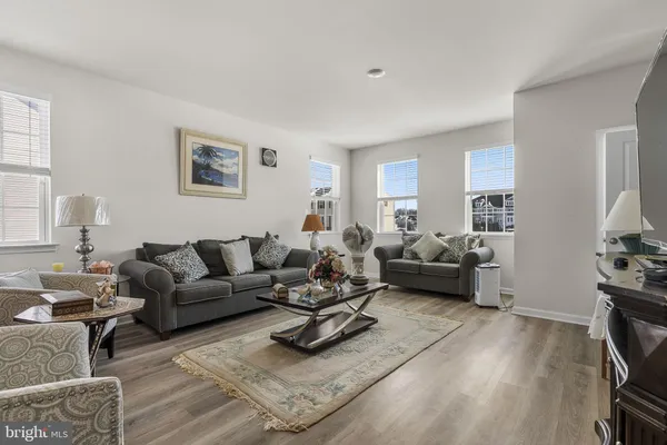 a living room with furniture a flat screen tv and a window