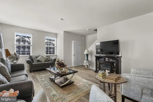 a living room with furniture wooden floor and windows
