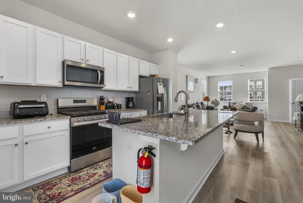 a kitchen with sink refrigerator dining table and chairs