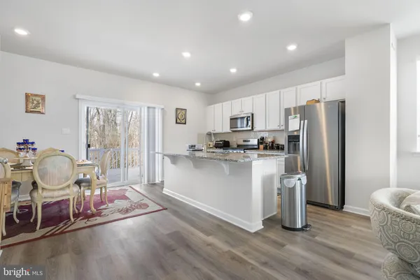 a living room with stainless steel appliances granite countertop furniture and a kitchen view