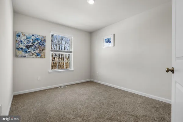 a bedroom with a bed a dresser and window