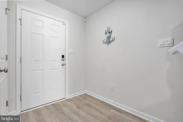 a view of a hallway with wooden floor and a bathroom