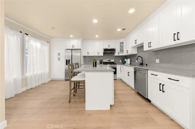 a kitchen with a sink a counter top space stainless steel appliances and cabinets