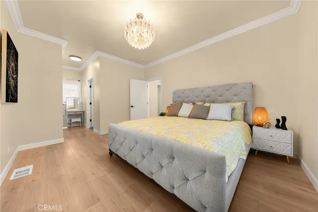 a bedroom with bed and a chandelier