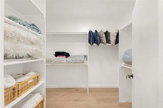 a view of walk in closet with clothes and shoes