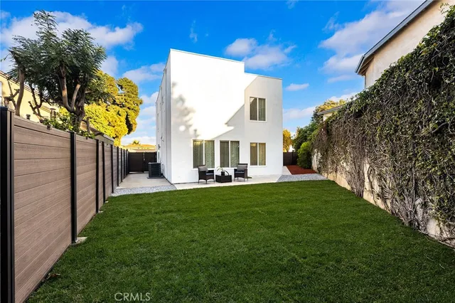 a view of a house with backyard and a tree