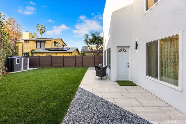 a view of a backyard with table and chairs with wooden fence