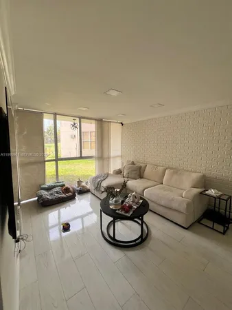 a living room with furniture a rug and a large window