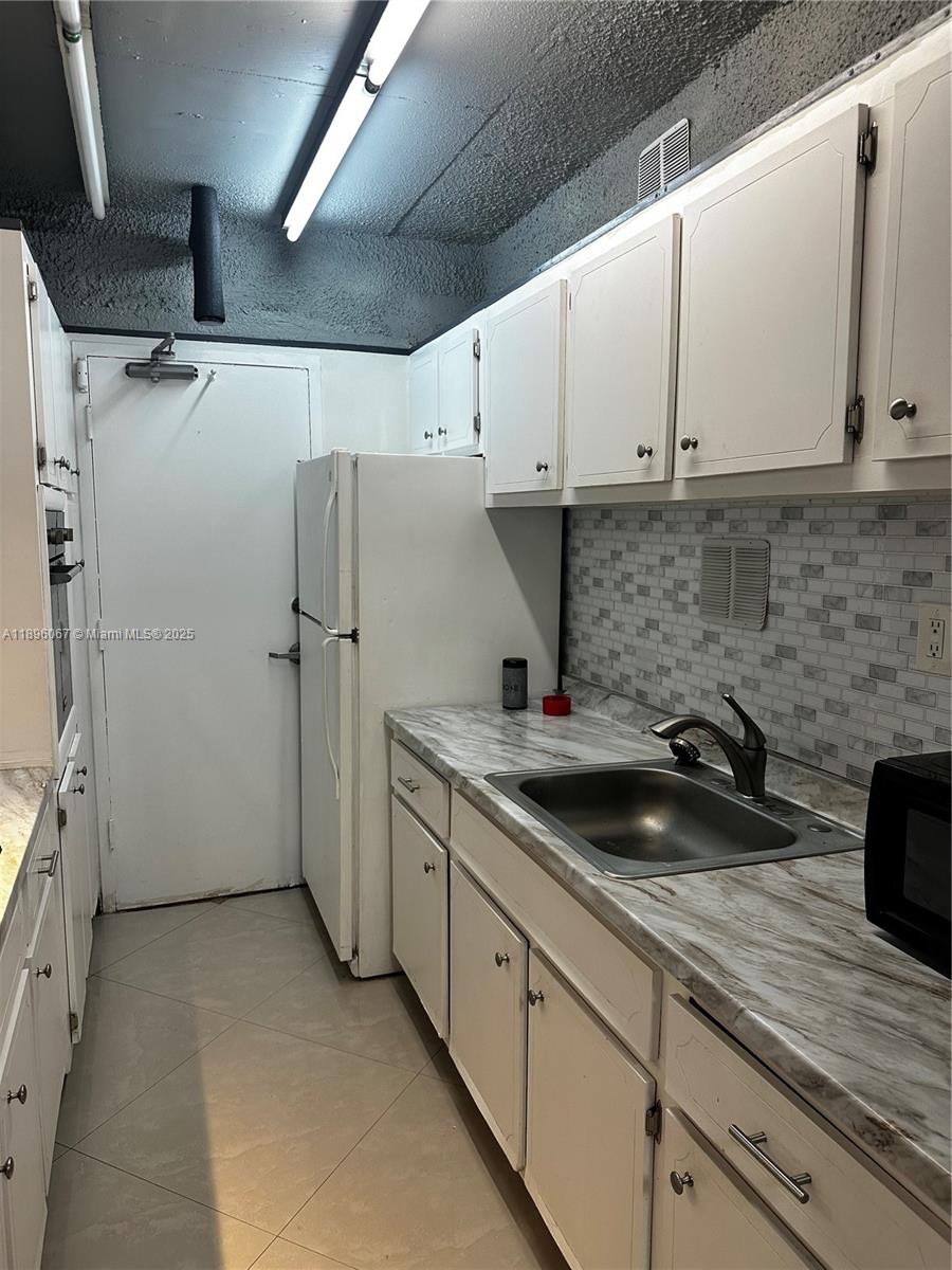 1200 West Avenue, Unit 914 Miami Beach, FL 33139 - Photo 18 of 38 a kitchen with a sink and refrigerator