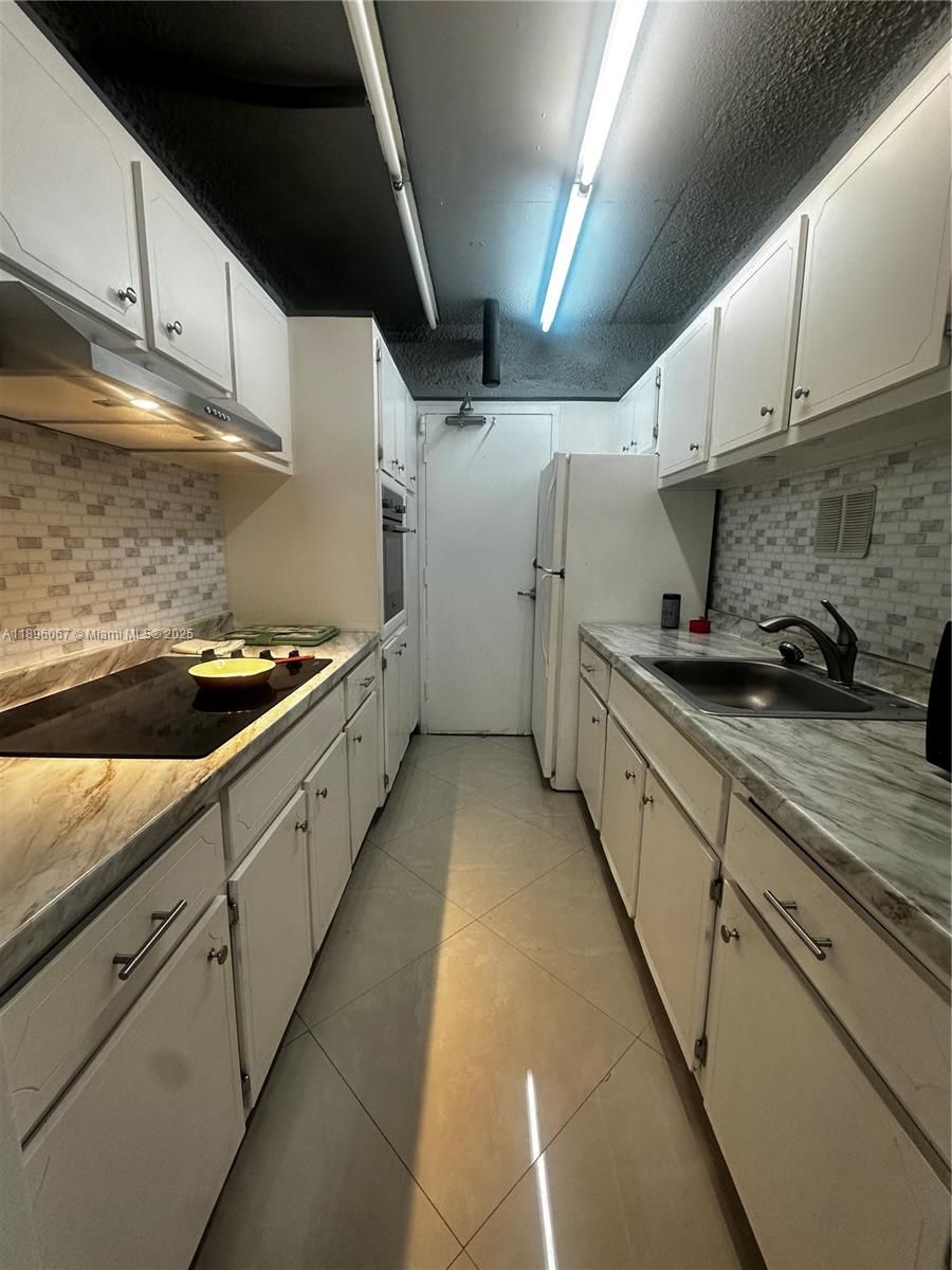 1200 West Avenue, Unit 914 Miami Beach, FL 33139 - Photo 22 of 38 a kitchen with granite countertop a sink and cabinets