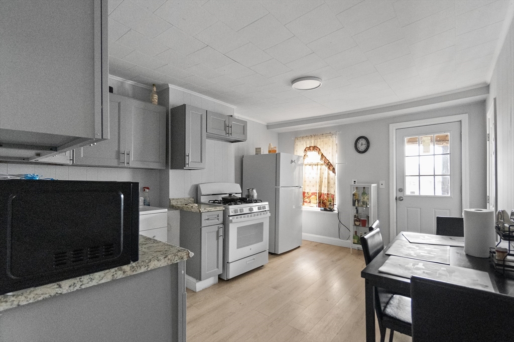 225 London Street Boston, MA 02128 - Photo 2 of 10 a kitchen with a stove a sink and a microwave