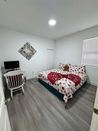 a bedroom with a bed and wooden floor