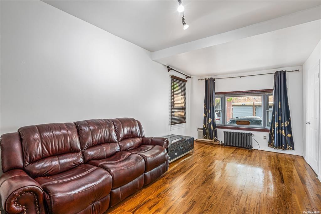 150-12 107th Avenue Queens, NY 11433 - Photo 3 of 16 a living room with a couch and a wooden floor