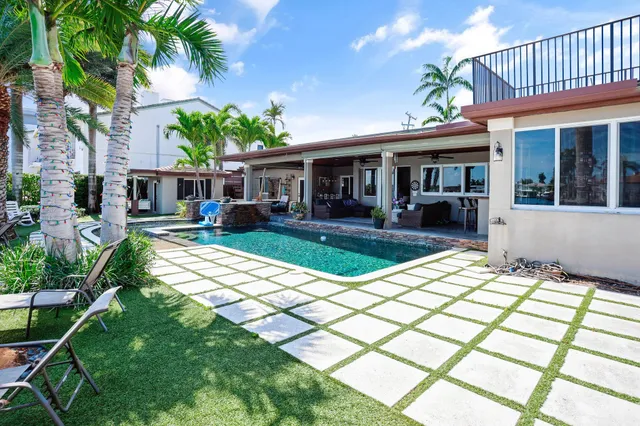 a view of a house with backyard and sitting area