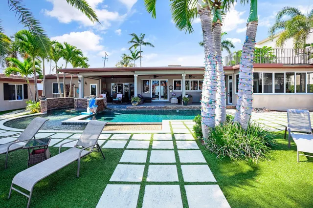 a view of a house with backyard and sitting area