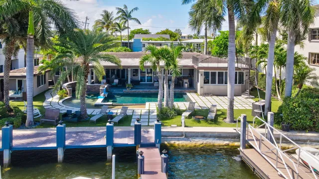 an aerial view of a house with a garden and lake view