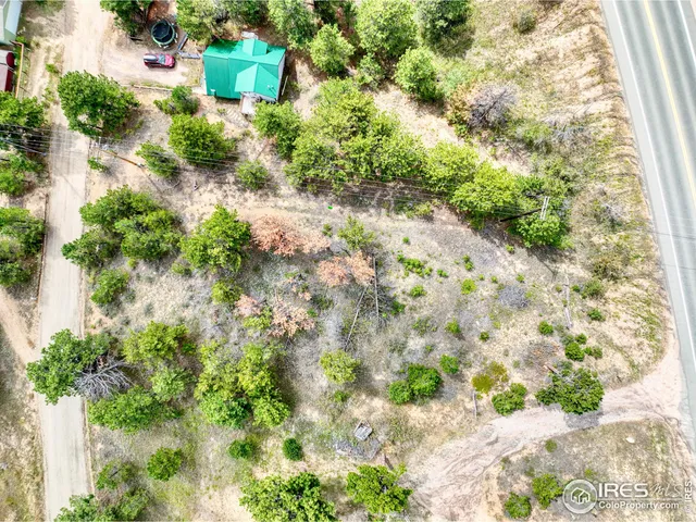 an aerial view of residential house with space and trees all around