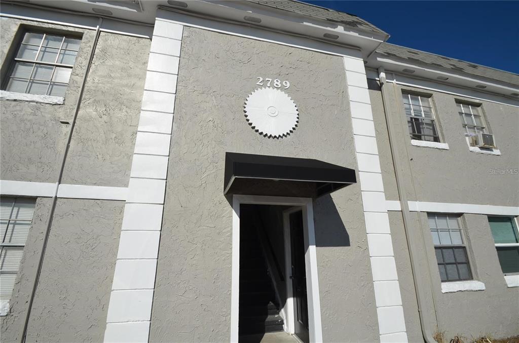 a view of a hallway with entryway wooden floor and door