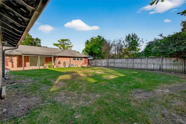 a view of an house with backyard space and balcony