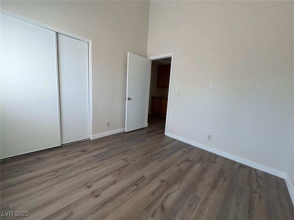 635 Delorean Drive North Las Vegas, NV 89081 - Photo 15 of 22 Unfurnished bedroom with wood finished floors, a closet, and a high ceiling