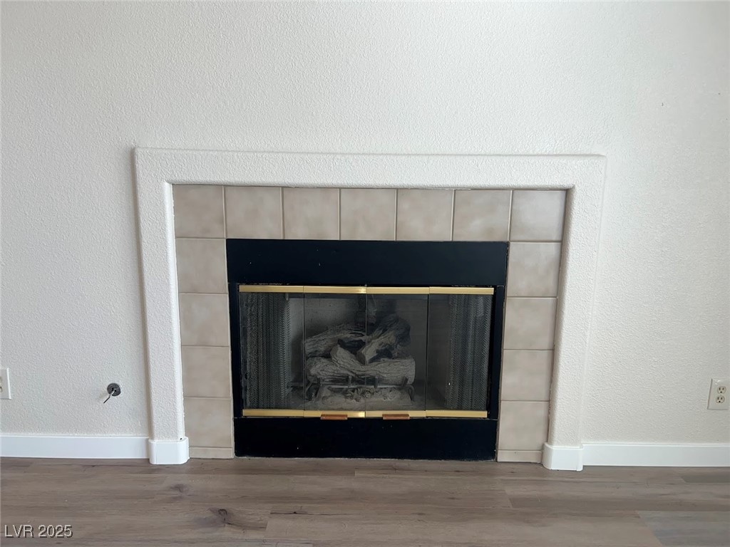635 Delorean Drive North Las Vegas, NV 89081 - Photo 18 of 22 Detailed view of a textured wall, a tile fireplace, and wood finished floors