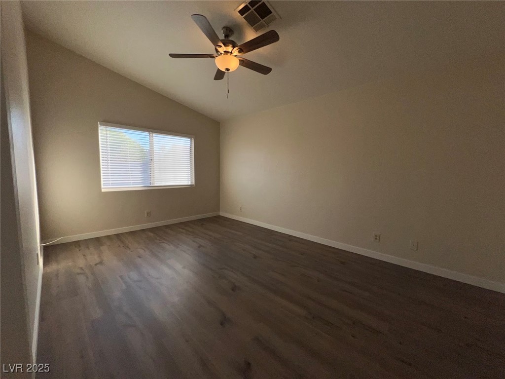 635 Delorean Drive North Las Vegas, NV 89081 - Photo 8 of 22 Spare room with vaulted ceiling, dark wood-type flooring, and a ceiling fan
